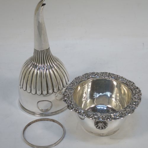 A very handsome Antique Georgian Sterling Silver wine decanting funnel, having a round body with hand-chased half-fluted decoration, and a pull out strainer with a shell clip and a shell and scroll border. Made by William Eley and William Fearn of  London in 1826. The dimensions of this fine hand-made silver wine decanting funnel are height 15 cms (6 inches), diameter of cup 9.5 cms (3.75 inches), and it weighs approx. 198g (6.4 troy ounces).   