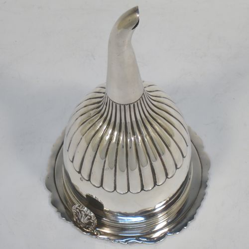 A very handsome Antique Georgian Sterling Silver wine decanting funnel, having a round body with hand-chased half-fluted decoration, and a pull out strainer with a shell clip and a shell and scroll border. Made by William Eley and William Fearn of  London in 1826. The dimensions of this fine hand-made silver wine decanting funnel are height 15 cms (6 inches), diameter of cup 9.5 cms (3.75 inches), and it weighs approx. 198g (6.4 troy ounces).   