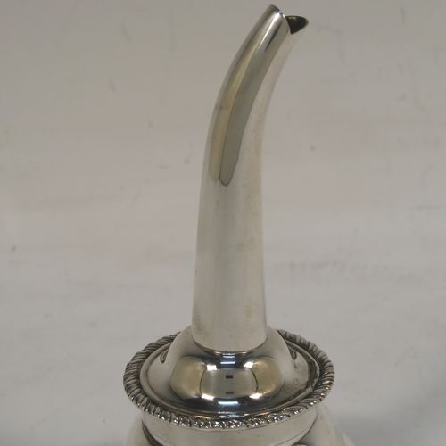 An elegant Scottish Sterling Silver wine decanting funnel, having a plain round body with a gold-gilt interior and applied gadroon borders, a cast shell side clip, and removable funnel. This handsome silver wine decanting funnel was made by Goodwins of Edinburgh in 2001. The dimensions of this fine hand-made silver wine decanting funnel are height 13 cms (5 inches), diameter of bowl 8 cms (3 inches), and it weighs approx. 127g (4 troy ounces).   