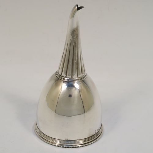 A very handsome Antique Georgian Sterling Silver wine decanting funnel, having a round body with hand-chased reeded and fluted decoration, and a pull-out strainer with an applied gadroon border. This elegant antique silver wine decanting funnel was made by William Akken III of London in 1800. The dimensions of this fine hand-made antique silver wine decanting funnel are height 14 cms (5.5 inches), diameter of cup 3.5 cms (3 inches), and it weighs approx. 142g (4.6 troy ounces).   