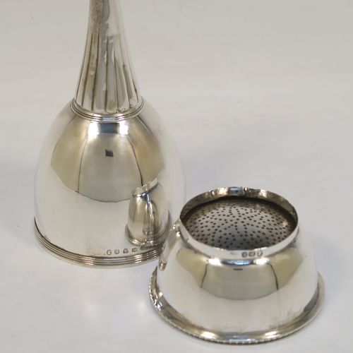 A very handsome Antique Georgian Sterling Silver wine decanting funnel, having a round body with hand-chased reeded and fluted decoration, and a pull-out strainer with an applied gadroon border. This elegant antique silver wine decanting funnel was made by William Akken III of London in 1800. The dimensions of this fine hand-made antique silver wine decanting funnel are height 14 cms (5.5 inches), diameter of cup 3.5 cms (3 inches), and it weighs approx. 142g (4.6 troy ounces).   