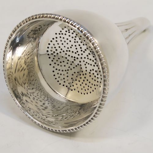 A very handsome Antique Georgian Sterling Silver wine decanting funnel, having a round body with hand-chased reeded and fluted decoration, and a pull-out strainer with an applied gadroon border. This elegant antique silver wine decanting funnel was made by William Akken III of London in 1800. The dimensions of this fine hand-made antique silver wine decanting funnel are height 14 cms (5.5 inches), diameter of cup 3.5 cms (3 inches), and it weighs approx. 142g (4.6 troy ounces).   