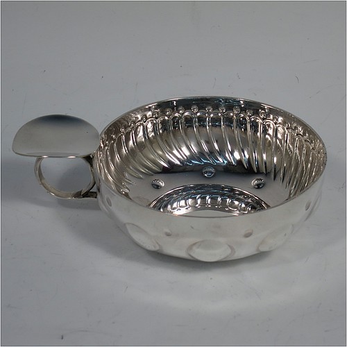 An Antique Victorian Silver French wine taster, having a round body, with hand-chased swirl-fluted and dimple decoration, a loop handle with plain thumb-piece, and sitting on a concave base with nine hand-chased beads running around the inside. Made in Paris, France ca. 1890, with a Minerva 1st Quality mark, indicating 950 standard silver. The dimensions of this fine hand-made antique silver wine taster or testavine are diameter 8 cms (3 inches), and height 3 cms (1.3 inch), and it weighs approx. 100g (3.2 troy ounces).    