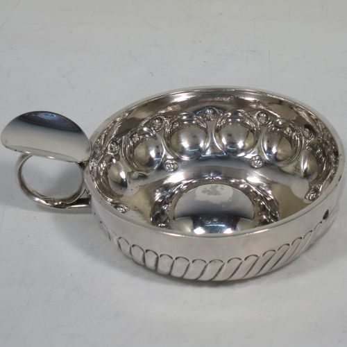 A very pretty Antique Victorian Silver wine taster, having a round body, with hand-chased fluted and ball decoration, a loop handle with thumb-piece, and sitting on a base with convex center. Made in Paris, France ca. 1890, with a Minerva 1st Quality mark, indicating 950 standard silver. The dimensions of this fine hand-made antique silver wine taster testavine are diameter 9 cms (3.5 inches), height 3.5 cms (1.3 inch), and it weighs approx. 110g (3.5 troy ounces).    