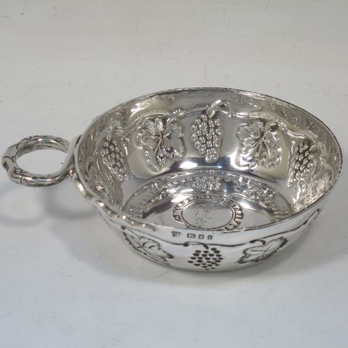 A large, heavy, and very handsome Sterling Silver testavine or wine taster, having a round body, with hand-chased grape-vine decoration, a cast snake head loop handle, and sitting on a flat base with bead-work decoration and inlet coin. Made by D. and J. Welby of London in 1925. The dimensions of this fine hand-made silver wine taster testavine are diameter 9.5 cms (3.75 inches), and height 3 cms (1.25 inch), and it weighs approx. 96g (3 troy ounces).   