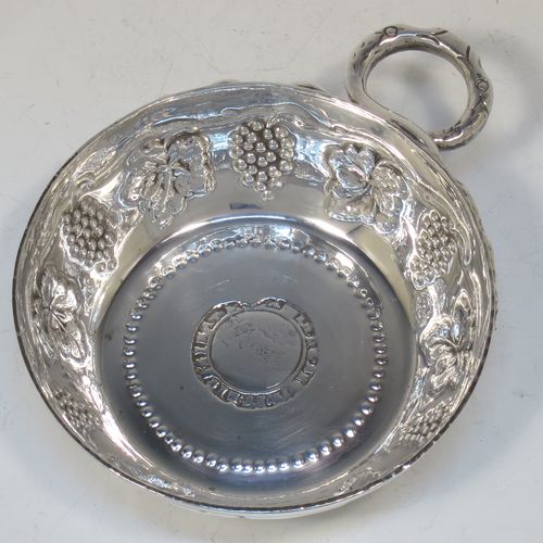 A large, heavy, and very handsome Sterling Silver testavine or wine taster, having a round body, with hand-chased grape-vine decoration, a cast snake head loop handle, and sitting on a flat base with bead-work decoration and inlet coin. Made by D. and J. Welby of London in 1925. The dimensions of this fine hand-made silver wine taster testavine are diameter 9.5 cms (3.75 inches), and height 3 cms (1.25 inch), and it weighs approx. 96g (3 troy ounces).   