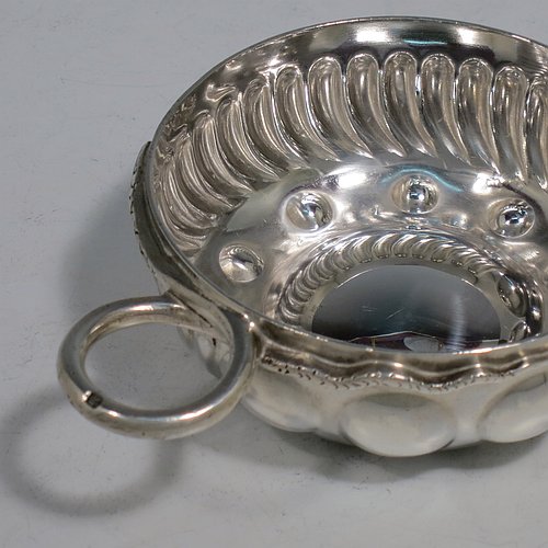 An Antique Victorian Silver French wine taster, having a round body, with hand-chased swirl-fluted decoration, a cast snake head loop handle, and sitting on a concave base with eleven hand-chased beads running around the inside. Made in Paris, France ca. 1890, with a Minerva 1st Quality mark, indicating 950 standard silver. The dimensions of this fine hand-made antique silver wine taster or testavine are diameter 8 cms (3 inches), and height 3 cms (1.3 inch), and it weighs approx. 90g (3 troy ounces).    