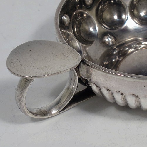 A very pretty Antique Victorian Silver wine taster, having a round body, with hand-chased fluted and ball decoration, a loop handle with thumb-piece, and sitting on a flat base. Made in Paris, France ca. 1890, with a Minerva 1st Quality mark, indicating 950 standard silver. The dimensions of this fine hand-made antique silver wine taster testavine are diameter 8 cms (3 inches), height 2.5 cms (1 inch), and it weighs approx. 69g (2.2 troy ounces).  