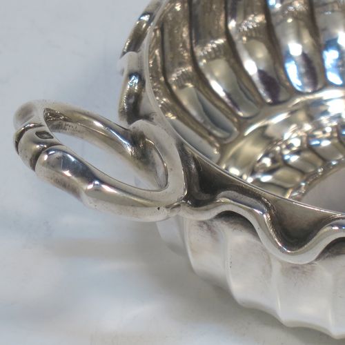 An Antique Victorian Silver French tasse de vin or wine taster, having a round body, with hand-chased fluted decoration, an applied cast snake head loop handle, and sitting on a concave base. Made in Paris, France ca. 1900, with a Minerva 1st Quality mark, indicating 950 standard silver. The dimensions of this fine hand-made antique silver wine taster or testavine are diameter 9 cms (3.5 inches), and height 4 cms (1.5 inch), and it weighs approx. 105g (3.4 troy ounces).  