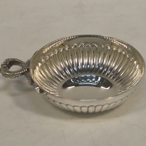 A very elegant Sterling Silver tasse de vin or wine taster, having a round body with hand-chased fluted decoration, an applied cast snake head loop handle, and sitting on a flat base. Made by John Henry Odell of London in 1969. The dimensions of this fine hand-made silver wine taster or testavine are diameter 9 cms (3.5 inches), and height 2.5 cms (1 inch), and it weighs approx. 93g (3 troy ounces).  