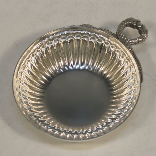 A very elegant Sterling Silver tasse de vin or wine taster, having a round body with hand-chased fluted decoration, an applied cast snake head loop handle, and sitting on a flat base. Made by John Henry Odell of London in 1969. The dimensions of this fine hand-made silver wine taster or testavine are diameter 9 cms (3.5 inches), and height 2.5 cms (1 inch), and it weighs approx. 93g (3 troy ounces).  