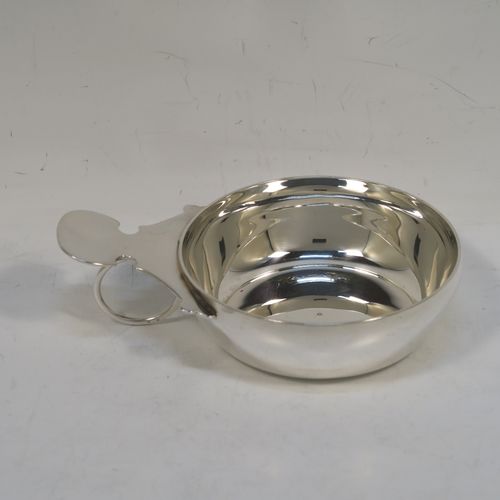 A very elegant Sterling Silver wine taster, having a plain round body with convex sides, a loop handle with thumb-piece, and sitting on a flat base. This handsome silver wine taster was made by J. A. Campbell of London in 1984. The dimensions of this fine hand-made silver wine taster testavine are diameter 8 cms (3 inches), height 2.5 cms (1 inch), and it weighs approx. 99g (3 troy ounces).   