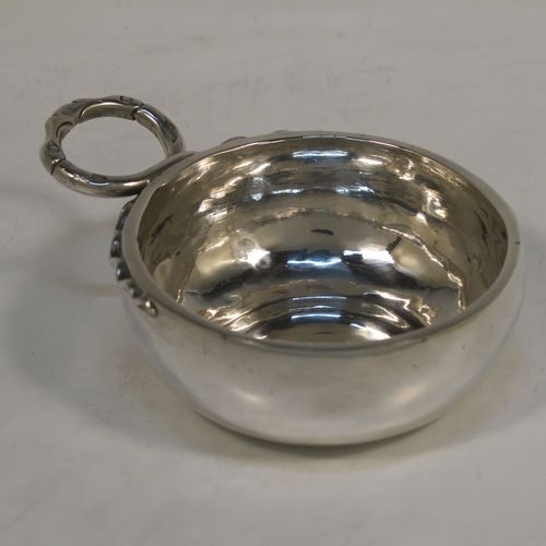 An Antique Victorian Silver French wine taster, having a plain round bellied body, a cast intertwined snake head loop handle, and sitting on a concave base. This elegant silver wine taster was made in Paris, France in ca. 1900, with a Minerva 1st Quality mark, indicating 950 standard silver. The dimensions of this fine hand-made antique silver wine taster or testavine are diameter 8 cms (3.25 inches), and height 3 cms (1.3 inch), and it weighs approx. 83g (2.7 troy ounces).  