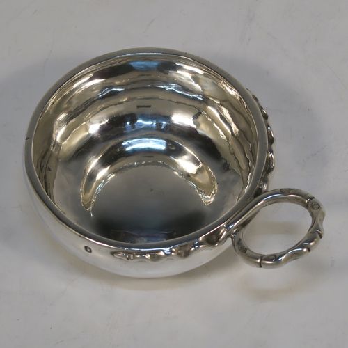 An Antique Victorian Silver French wine taster, having a plain round bellied body, a cast intertwined snake head loop handle, and sitting on a concave base. This elegant silver wine taster was made in Paris, France in ca. 1900, with a Minerva 1st Quality mark, indicating 950 standard silver. The dimensions of this fine hand-made antique silver wine taster or testavine are diameter 8 cms (3.25 inches), and height 3 cms (1.3 inch), and it weighs approx. 83g (2.7 troy ounces).  